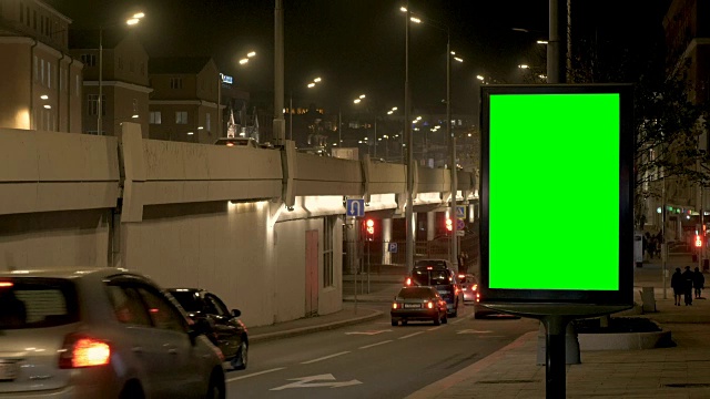 繁忙街道上的一个绿屏广告牌。视频素材