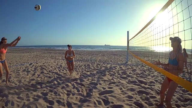 女子沙滩排球和一个女孩击球的视频。——慢动作视频素材