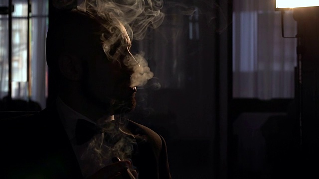 一个抽着雪茄，烟瘾很大的剪影男人视频素材