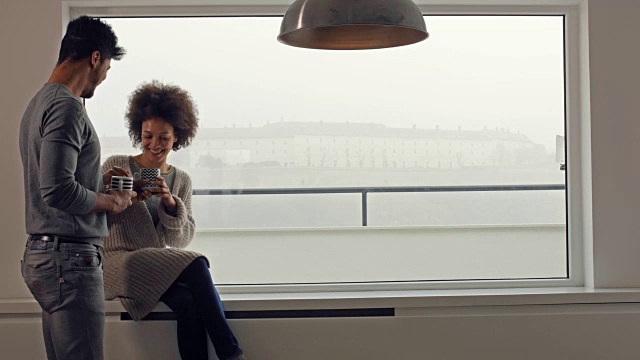 一对幸福的黑人情侣在窗边享受咖啡时光。视频素材