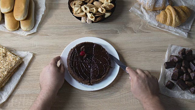 食物成瘾者会把蛋糕切成小块，用糖果吃压力，俯视图视频素材