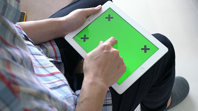 一个人在玩绿色屏幕的数字平板电脑视频素材