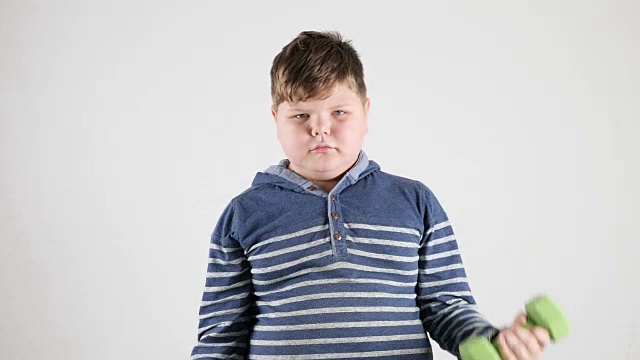 一个年轻的胖男孩用哑铃每秒钟50次抽吸肱二头肌视频下载