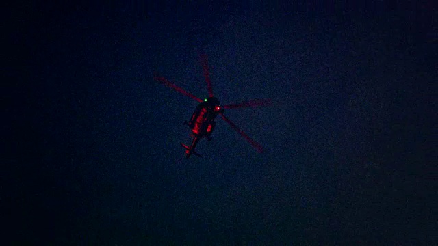 照亮的直升机在夜晚在城市上空飞行视频下载