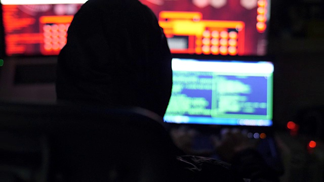 一名男性黑客在电脑屏幕上操作数据视频下载