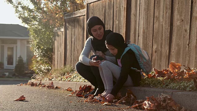 4K超高清:中东血统的母亲和女儿坐在路边视频下载