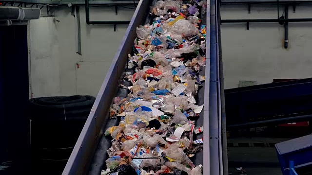 垃圾输送工在垃圾回收厂工作。视频素材