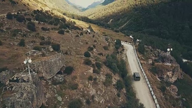 无人机拍摄的卡车在夏日沿着蜿蜒的山路行驶视频素材