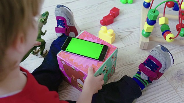 蹒跚学步的孩子使用绿屏智能手机视频素材