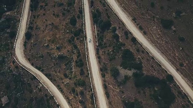 鸟瞰图白色汽车吉普车沿着蜿蜒的山路在夏天视频素材