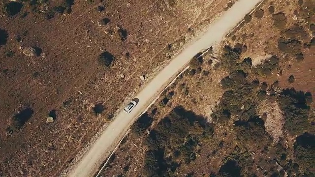 俯视图白色汽车吉普车行驶在山区公路沿着荒野视频素材