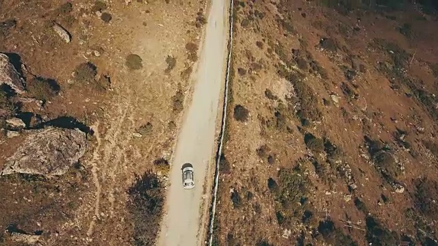 从上面看，白色汽车在蜿蜒的山路上行驶视频素材