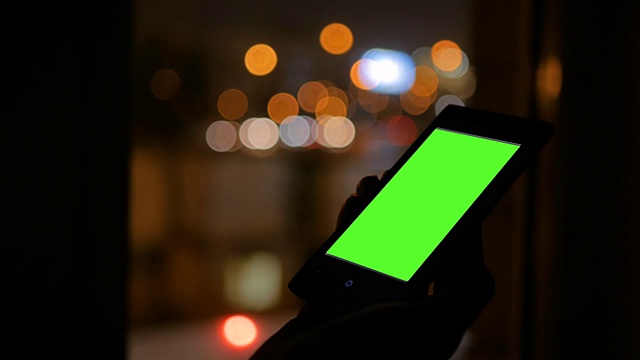 一个女人在看绿色屏幕的智能手机视频素材