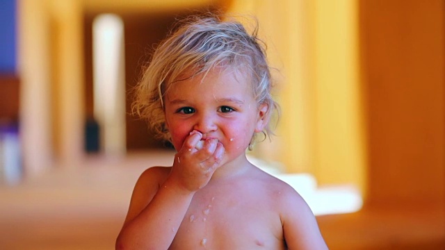 蹒跚学步的婴儿玩食物。儿童吃水果和吐水果的肖像。婴儿对食物流口水，表现出被宠坏了视频素材