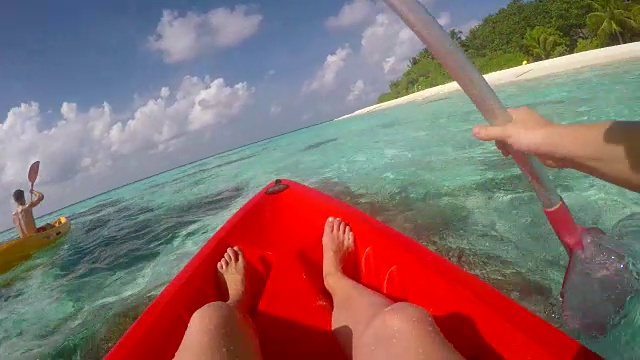 一个男人和女人夫妇皮划艇绕热带岛屿的观点。视频素材