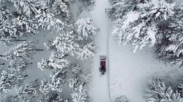 直下:拖拉机在白雪覆盖的路上行驶视频素材