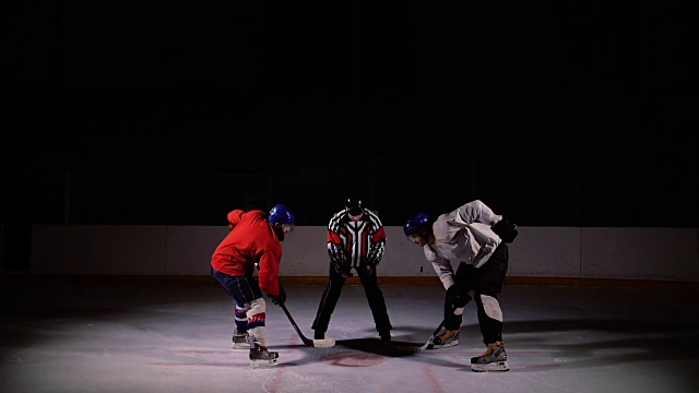 冰球裁判进行了一场对峙，两名球员开始争夺冰球。慢动作视频素材