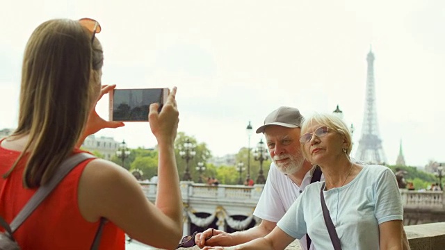 女儿在巴黎度假时给老父母拍照。靠近埃菲尔铁塔和塞纳河视频素材