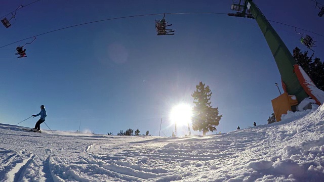 4K滑雪者滑雪和乘坐滑雪缆车在阳光明媚，雪上滑雪斜坡，实时视频下载