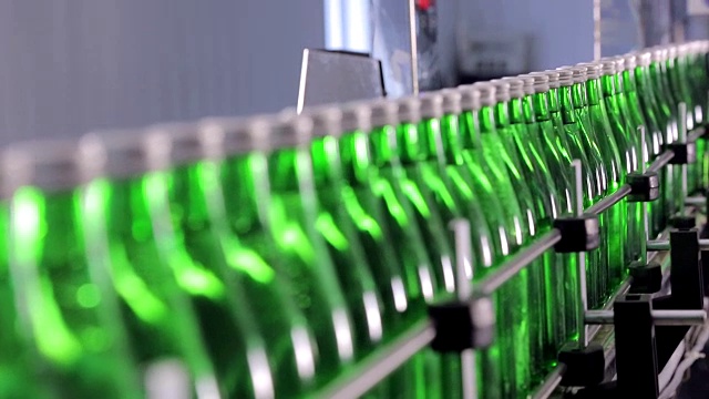 绿色矿泉水瓶沿着自动生产线移动。视频素材
