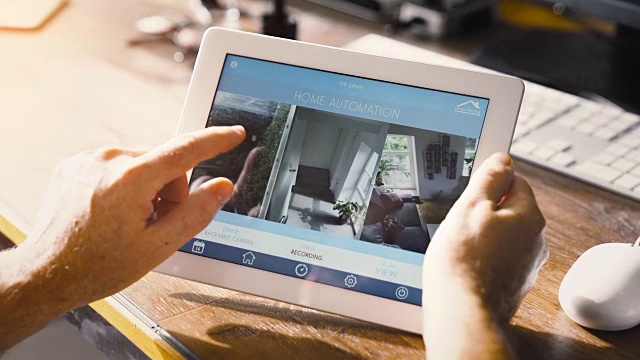 男人在智能设备上使用智能家居应用程序。智能房子自动化视频素材