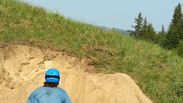 一个山地自行车手在土路上耍小把戏。——慢动作视频素材
