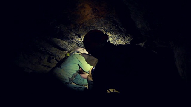 人类用手电筒探索黑暗的洞穴视频下载