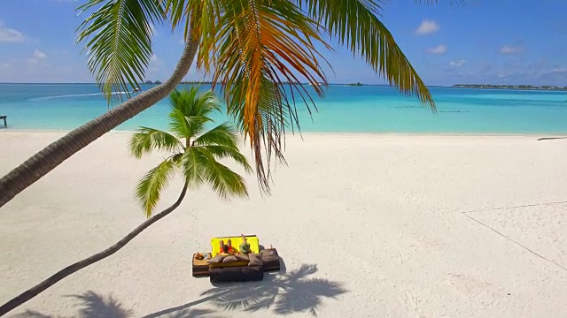 一对夫妇在热带岛屿度假酒店的海滩上闲逛的鸟瞰图。视频素材