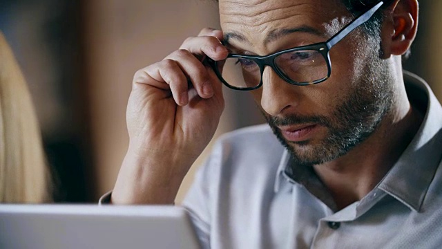 戴眼镜的男子使用平板电脑。公司业务团队工作办公室会议。三个白人商人和女商人聚在一起讨论策略。协作，成长，成功视频素材