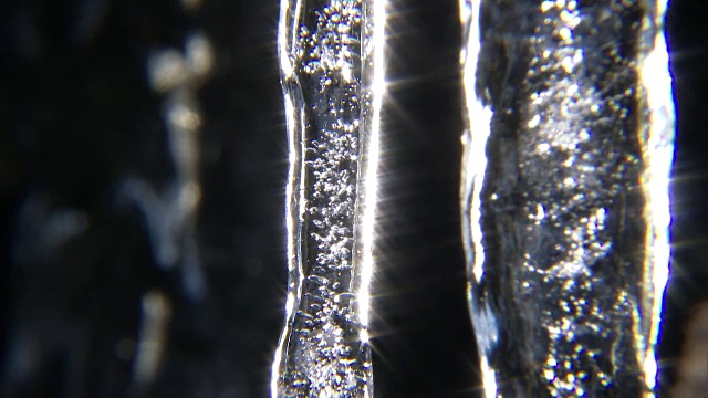 近距离拍摄的一个冰柱的顶端与水滴从冰柱。视频下载