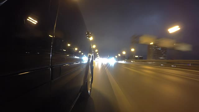 快速城市驾驶夜间道路POV通过城市在夜间时间推移左侧的汽车。低角度的观点。相机拍摄。门打开视频素材