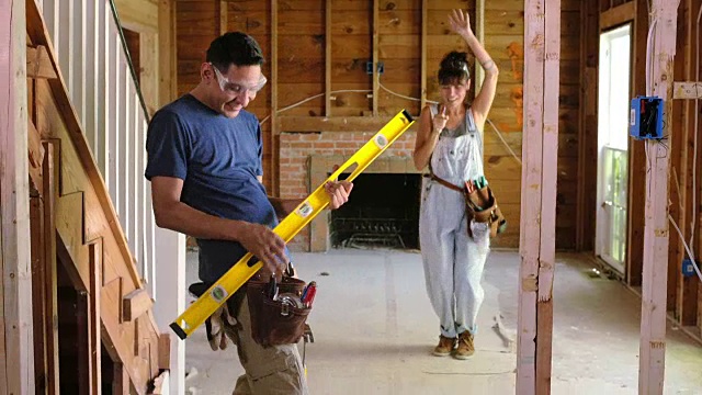 一个男人和一个女人拿着建筑工具一起跳舞。视频下载