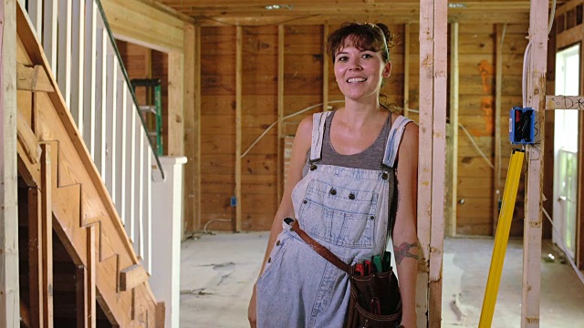 一个女人的肖像站在她的建筑项目的门框上视频下载