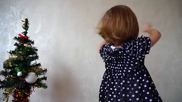 年轻美丽的女孩在圣诞树旁跳舞视频素材