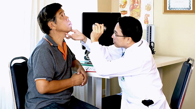亚洲年轻医生通过按压病人的颈部来检查视频下载