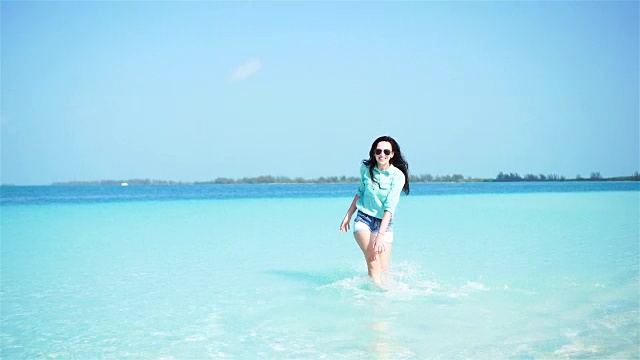 海滩上的年轻美女。快乐的女孩享受她的热带度假异国岛屿视频下载