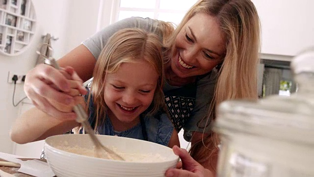 女孩和她妈妈一起学习烘焙。视频素材