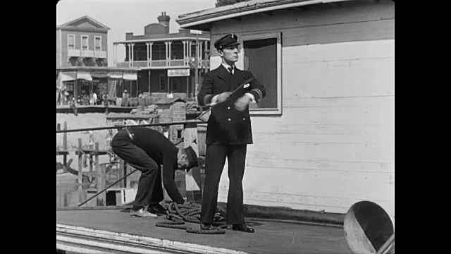 一名男子(巴斯特·基顿饰)在船员匆忙拉绳子时尴尬地摔倒了视频素材
