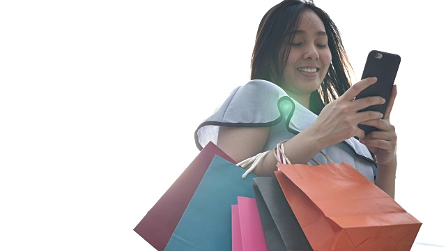 购物的亚洲女人拿着智能手机和信用卡视频下载