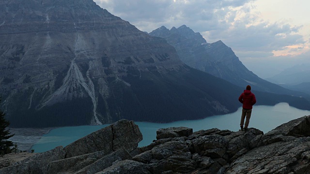 一个男人在一个高高的湖上的岩石小径上徒步旅行。视频素材