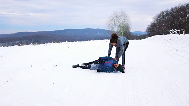 运动员和女友在雪地上跑步时受伤。视频下载