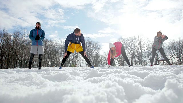 运动训练前在雪地上热身的一群年轻运动员。视频素材