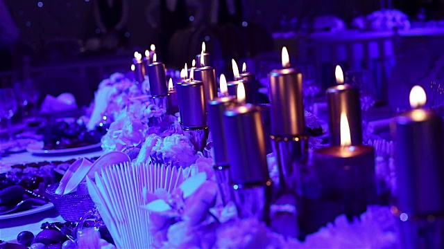 装饰蜡烛在桌子上，眼镜和圣诞蜡烛在桌子上，婚礼装饰，白色蜡烛与玻璃烛台，蜡烛与玻璃烛台，餐厅，室内，特写视频素材