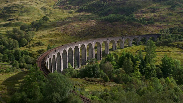 时间流逝。蒸汽火车经过弯曲的格伦芬南高架桥。格兰芬南，苏格兰高地，苏格兰，英国。视频素材