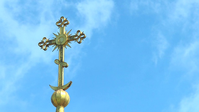 传统庙宇圆顶上的十字架，映衬着乌云密布的天空视频下载