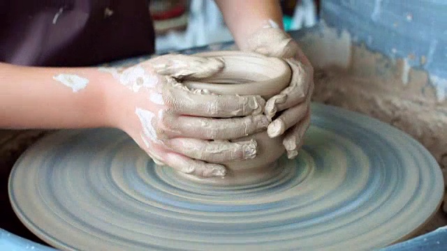 小女孩玩粘土在陶器轮上玩得很开心视频下载