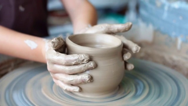 制作陶罐陶工陶土作坊陶土在装置上。大师。双手在陶土轮上工作，塑造一个陶土壶视频下载