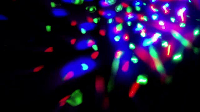 闪烁着闪亮的多色舞台灯光圆形运动娱乐迪斯科舞，聚光灯投射在黑暗中，五彩柔和的灯光聚光灯照在黑色上视频素材