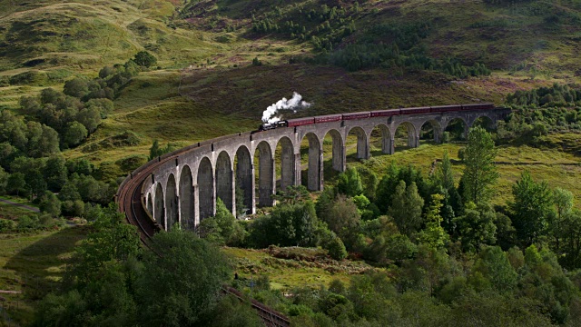 蒸汽火车经过弯曲的格伦芬南高架桥。格兰芬南，苏格兰高地，苏格兰，英国。视频素材