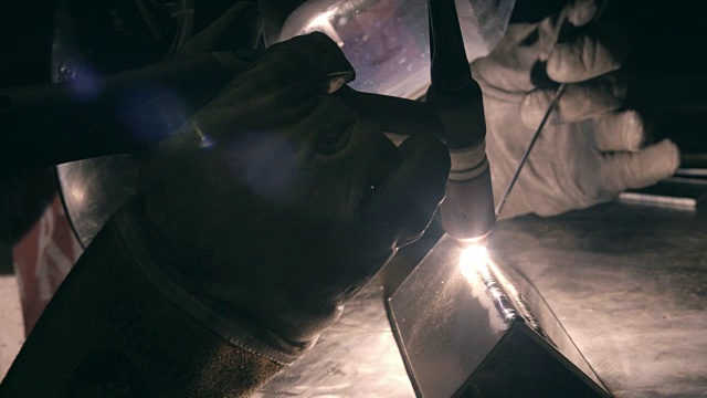 在工厂工作时戴着防护手套的焊工的特写视频素材